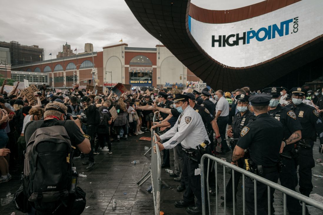 NYPD officers discharge pepper spray into a crowd of protesters.
